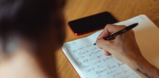 De que nos sirve… person writing on notebook