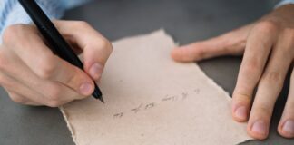Estilogràfiques. Cita. Tendal vermell person writing on white paper